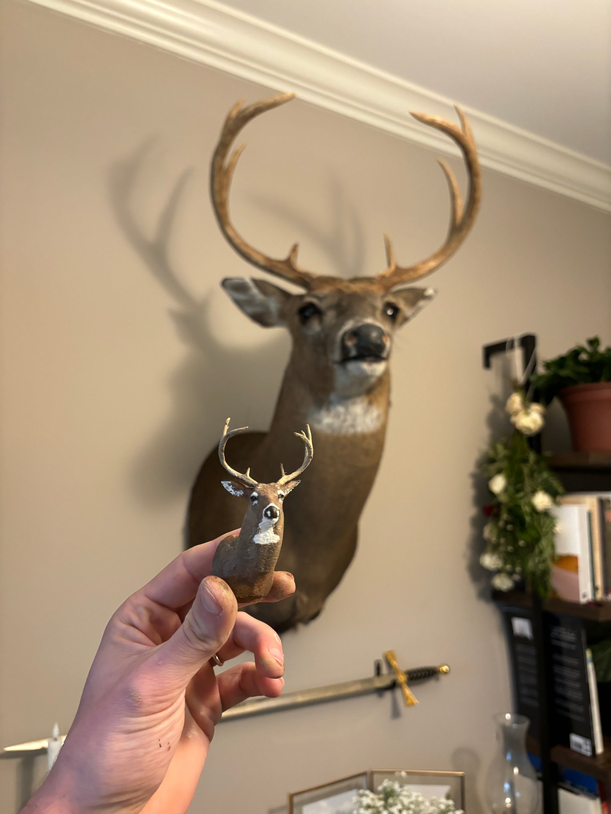 mini replica shoulder mount of deer next to the original deer